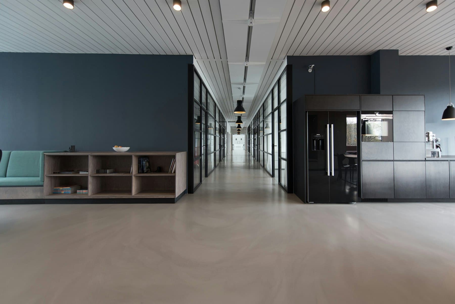 Polished commercial corridor and lounge with glass-walled offices